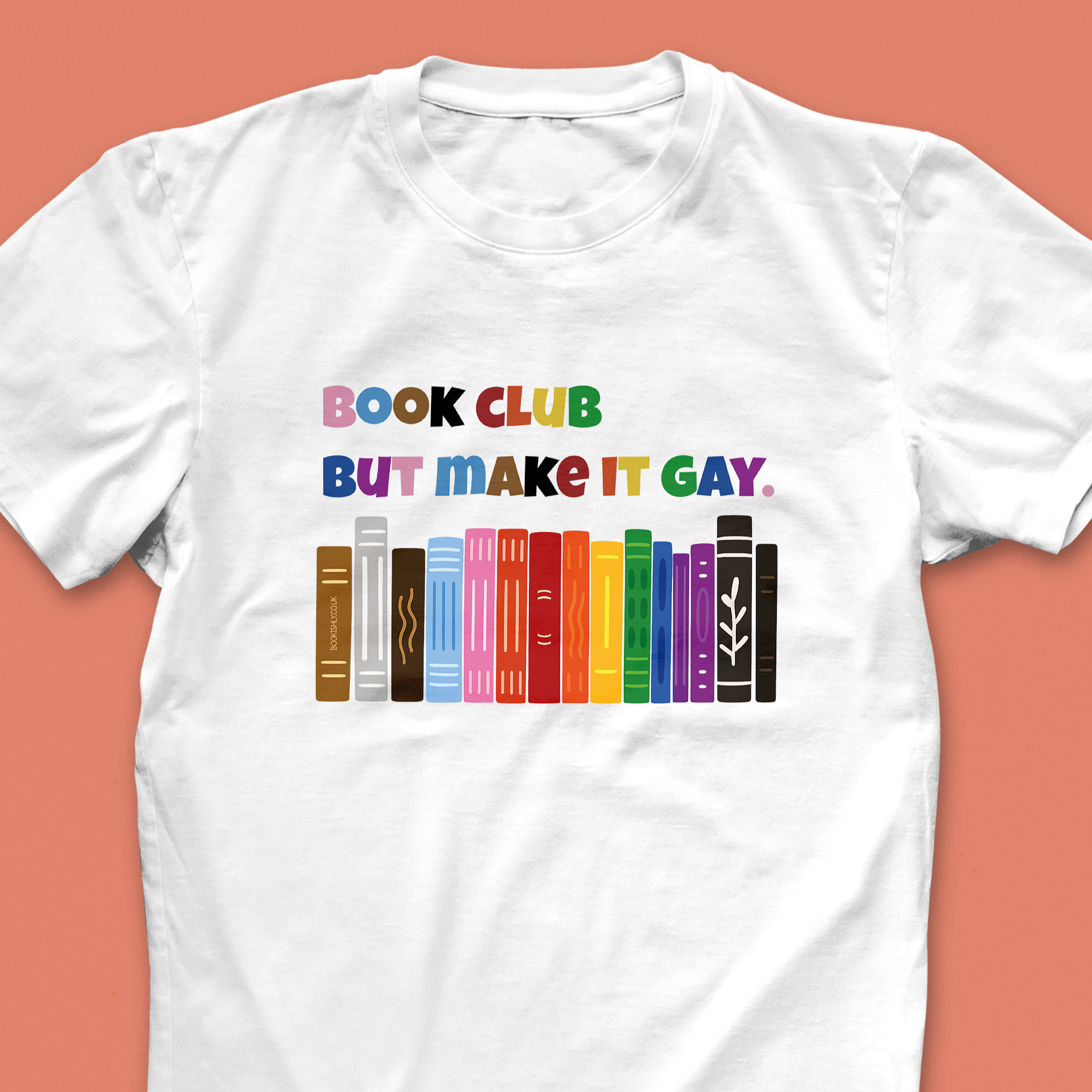 “Book Club But Make It Gay” T-shirt with rainbow book spines and bold multicolour text, designed for LGBTQ+ book lovers