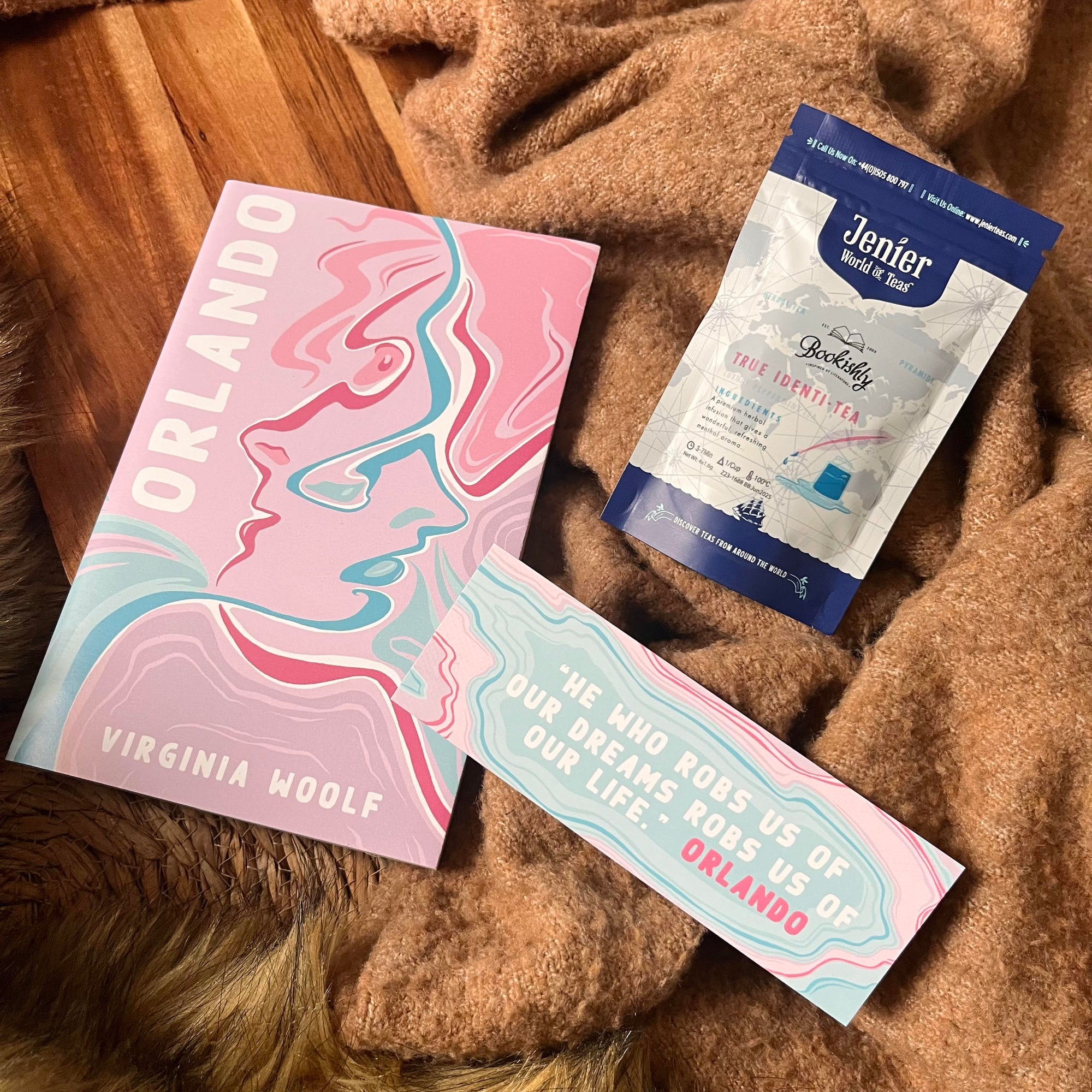 Bookishly edition of Orlando by Virginia Woolf with abstract pink and blue cover, paired with True Identitea and a matching quote bookmark – part of the monthly classic book subscription.