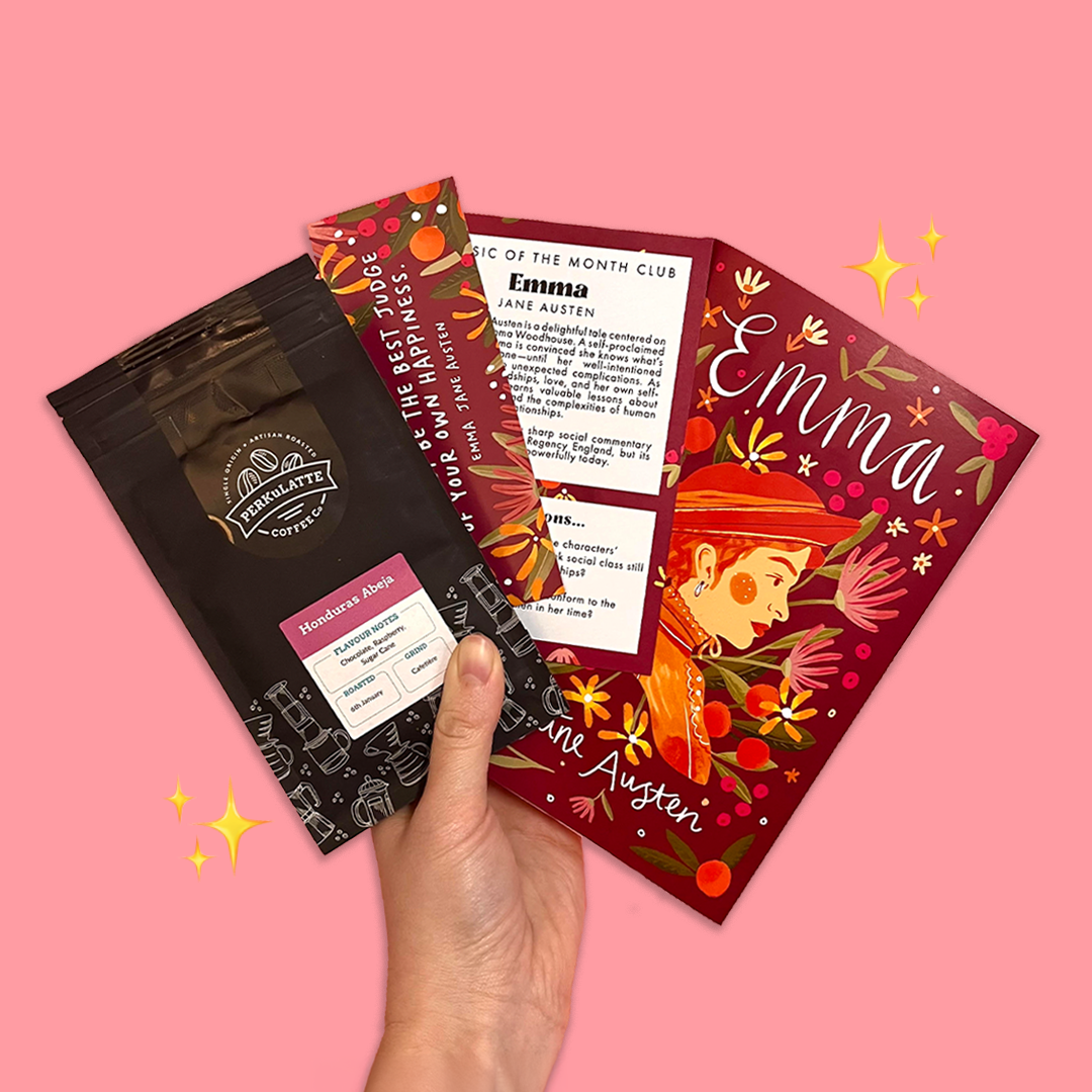 Hand holding Jane Austen’s Emma with bookmark, discussion card, and Perkulatte coffee sachet – part of the Bookishly classic book subscription gift box.