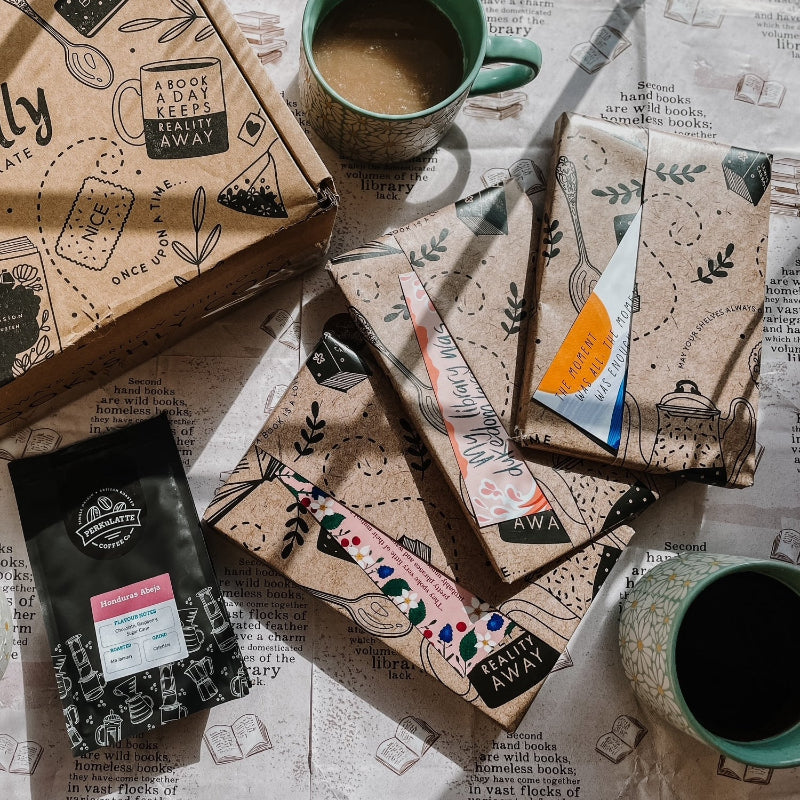 Classic book subscription box with a mug – books, coffee or tea sachets, and a Bookishly gift box laid out on a cosy background