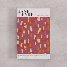 Bookishly edition of Jane Eyre by Charlotte Brontë with a pink and ochre patterned dust jacket and personalised message printed on the front cover.