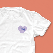 White T-shirt with small lilac heart design and the word “Smut” in handwritten lettering – a minimalist romance reader tee