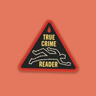 “True Crime Reader” sticker designed like a red and black stitched merit badge, with a chalk outline illustration on a black background.
