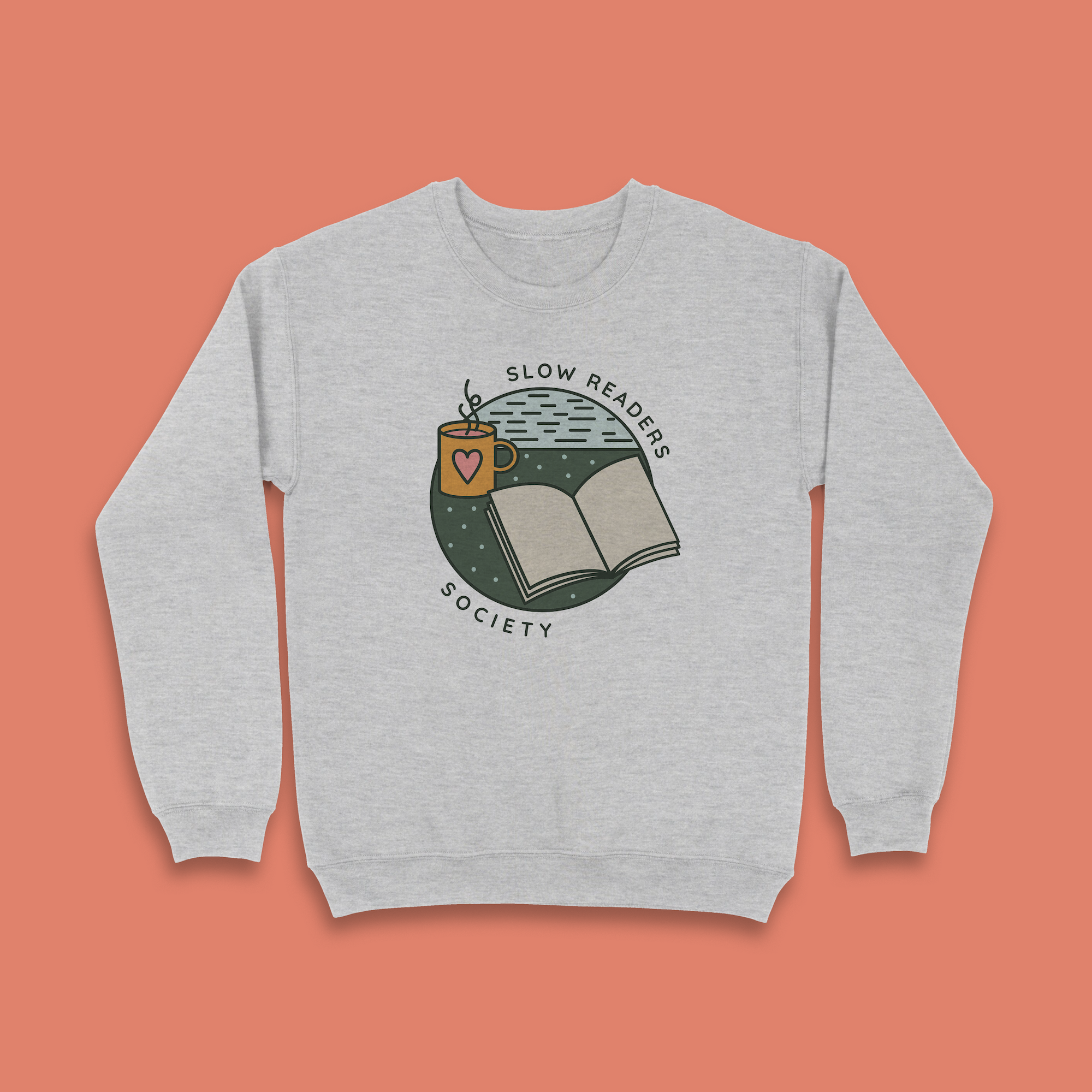 Grey sweatshirt with “Slow Readers Society” design featuring an open book, steaming mug with heart, and illustrated night sky.