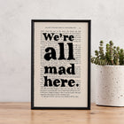 Framed book page print with the quote “We’re all mad here” from Alice’s Adventures in Wonderland.