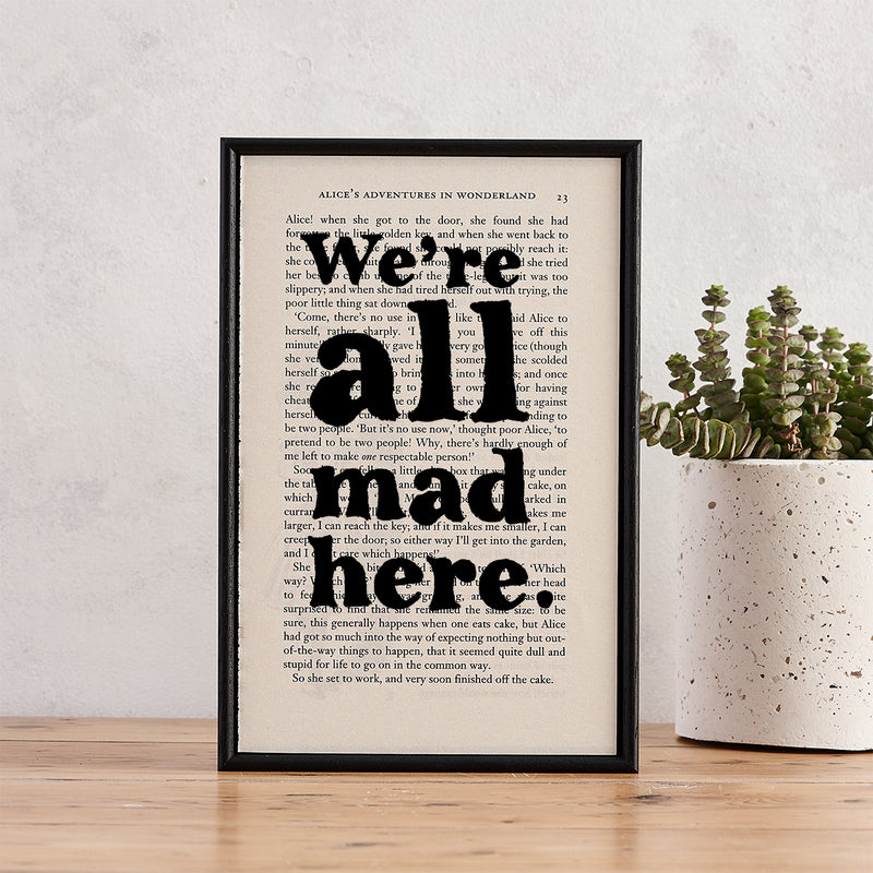 Framed book page print with the quote “We’re all mad here” from Alice’s Adventures in Wonderland.