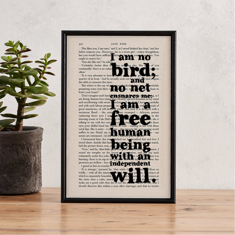 Framed book page art featuring the quote “I am no bird; and no net ensnares me: I am a free human being with an independent will” from Jane Eyre.