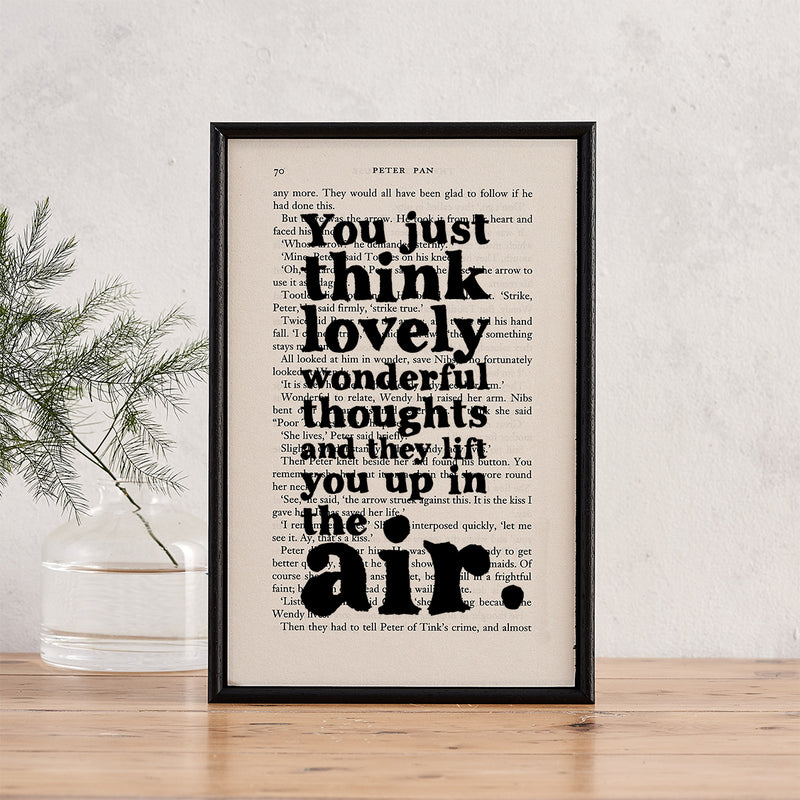 Framed book page print featuring the quote “You just think lovely wonderful thoughts and they lift you up in the air” from Peter Pan.