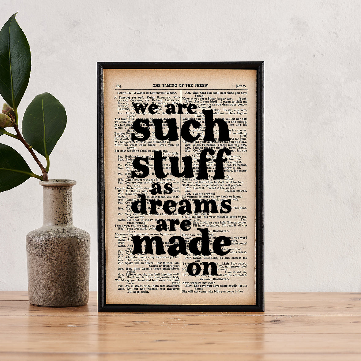 Framed book page print with the quote “We are such stuff as dreams are made on” printed in black text onto a page from The Complete Works of William Shakespeare.